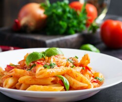 Classic italian pasta penne alla arrabiata with basil and freshly grated parmesan cheese