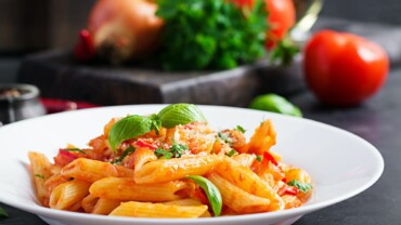 Classic italian pasta penne alla arrabiata with basil and freshly grated parmesan cheese