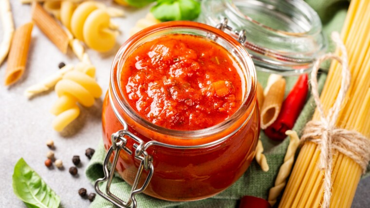 Glass jar with homemade classic spicy tomato pasta or pizza sauce.