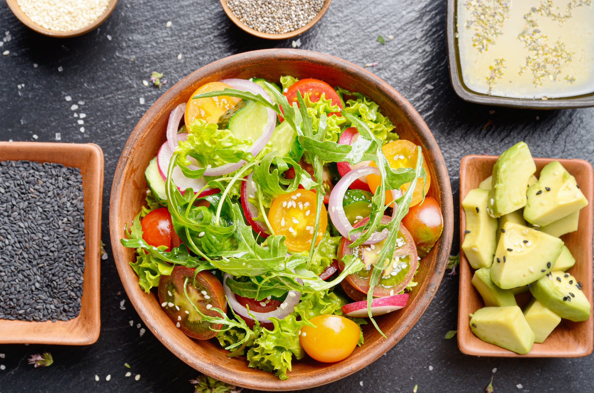 Top view at Clay dish with vegetable salad of lettuce, cherry to